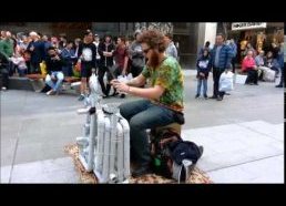 Gatvės muzikantas groja plastikiniais vamzdžiais